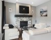 Natural gas fireplace in the living room brings together the warm, rich palette of the LVP flooring and the timeless color of the walls