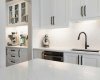 View from gleaming quartz-topped island to custom butler’s pantry