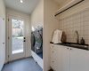Laundry room, back entrance door and lots of storage/closet space. Notice the washer and dryer sitting on quartz base with drainage behind for additional peace of mind.