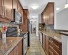 Kitchen features granite counters, stainless steel appliances and pantry