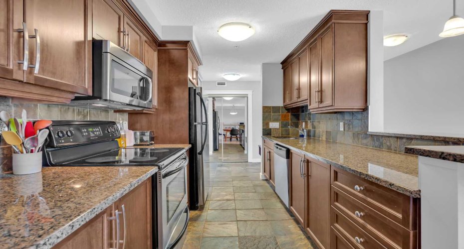 Kitchen features granite counters, stainless steel appliances and pantry