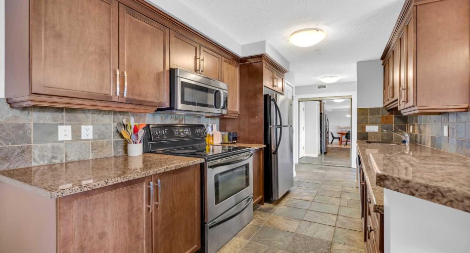 Kitchen features granite counters, stainless steel appliances and pantry