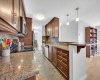 Kitchen features granite counters, stainless steel appliances and pantry