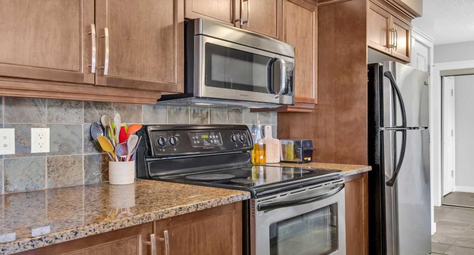 Kitchen features granite counters, stainless steel appliances and pantry