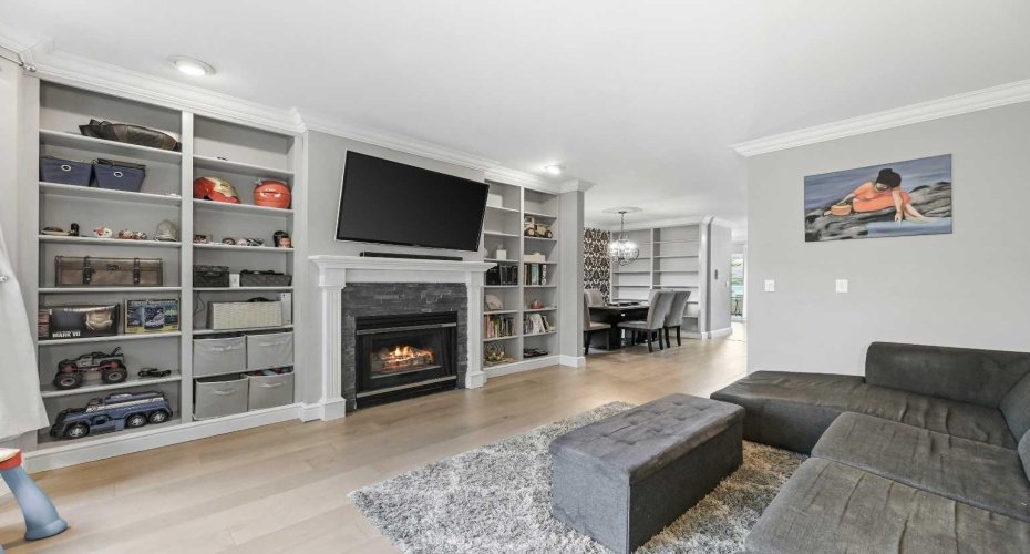 Another view of the living Room with Flat ceiling, Crown Moulding and recessed lights. Continuation of the new Hardwood flooring.