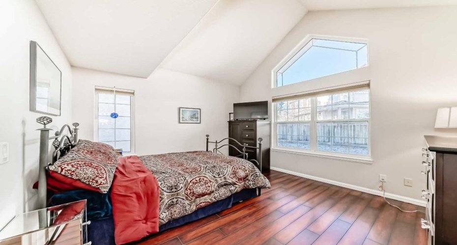Tranquil primary bedroom with abundant natural light streaming through large windows, creating a bright and serene retreat.