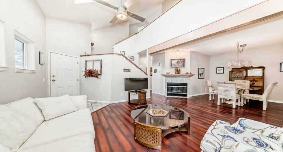 Warm and open living room with a classic fireplace, offering effortless transition to the dining area.