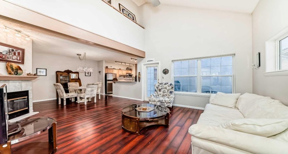 Warm and open living room with a classic fireplace, offering effortless transition to the dining area.