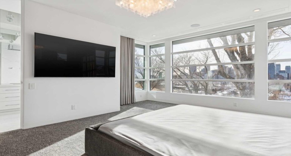 CORNER WINDOWS EXTEND THE VIEWS. WALL-MOUNTED TV