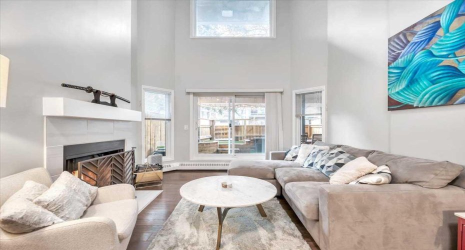 Living room with fireplace multiple windows facing west.