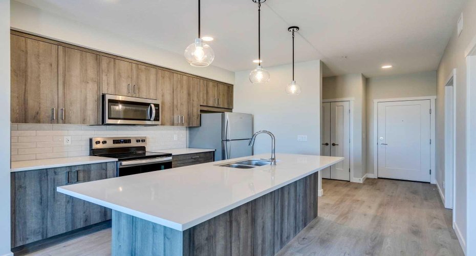 Kitchen features quartz counters, island with breakfast bar and lots ot storage space