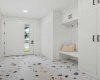 Designer tile in foyer with coat closet and bench