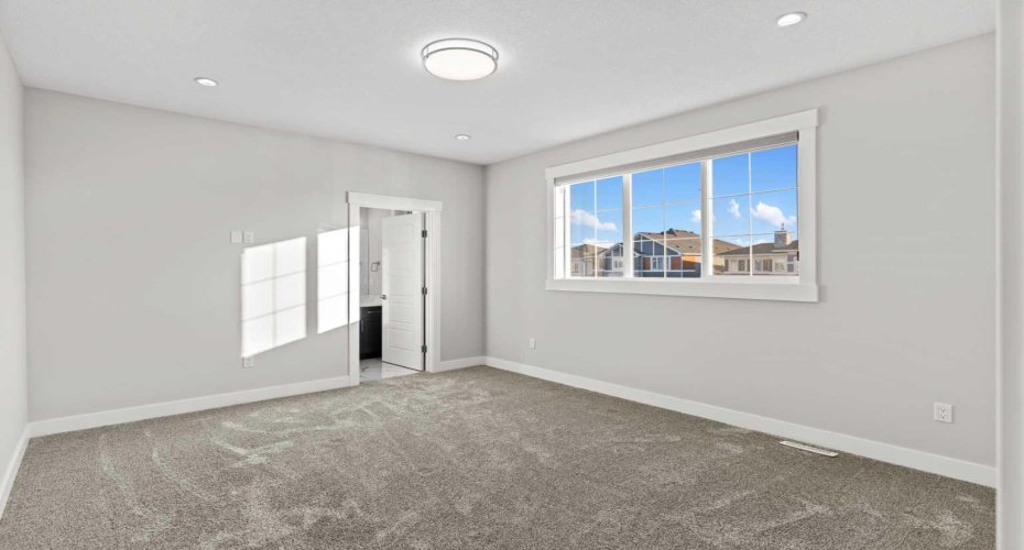 A generously sized secondary primary suite offers a private ensuite and walk in closet, providing elevated comfort and ideal accommodation for guests or multigenerational living.