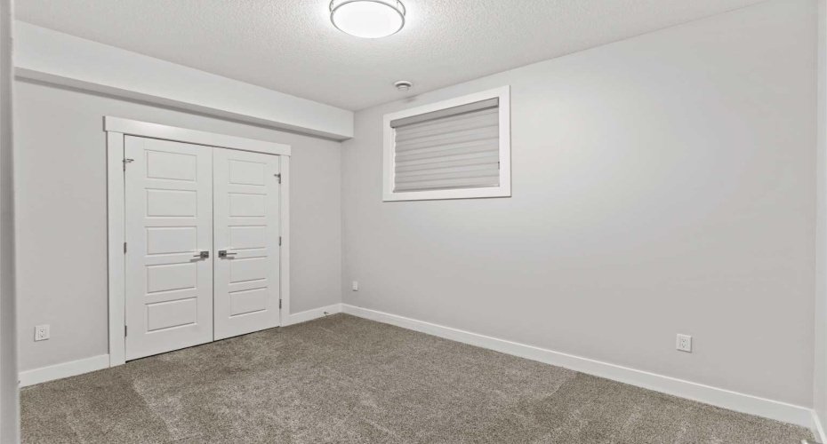 A comfortable basement bedroom featuring a generous closet offers ample storage and a private, versatile space ideal for guests, extended family, or rental use.