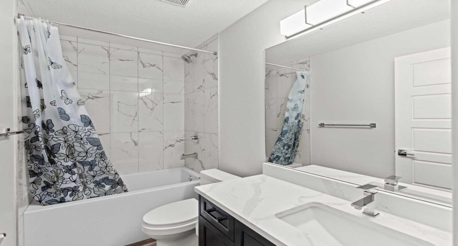 A well finished 4 piece basement bathroom features a full tub with tiled surround, modern vanity, and sleek fixtures, offering both style and everyday functionality for the lower level.