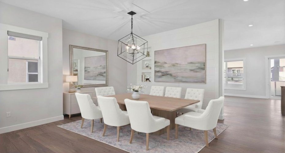 The formal dining area is elevated by a stunning custom feature wall with built in architectural niches, creating a refined focal point that complements the rich hardwood flooring and modern designer lighting.