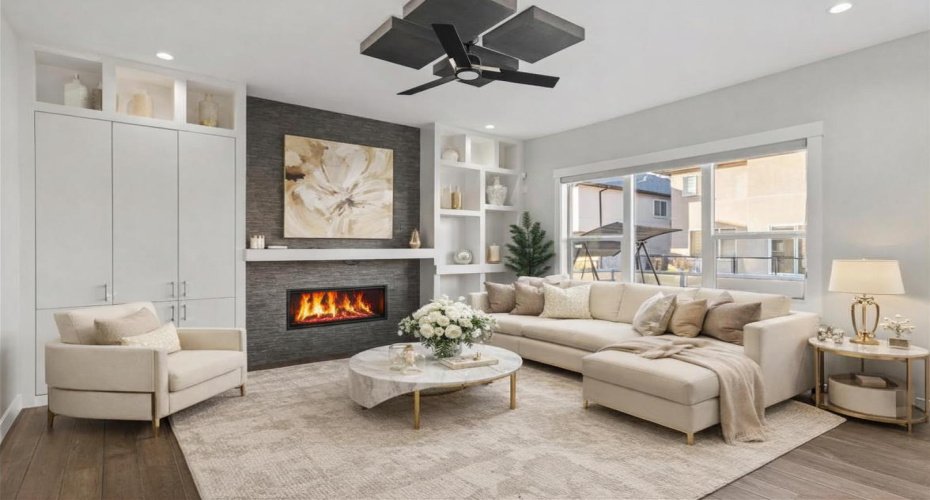 A sophisticated living area featuring floor to ceiling built ins, a sleek GAS FIREPLACE, and expansive windows that flood the space with natural light — perfectly designed for hosting, entertaining, or refined everyday relaxation.