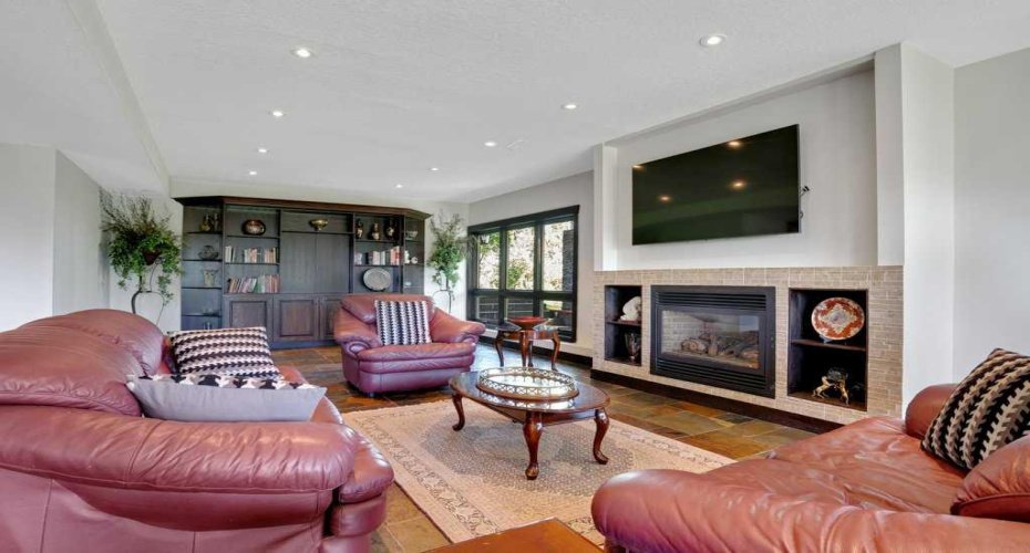 Lower level sitting area with built-in bookcase and gas fireplace