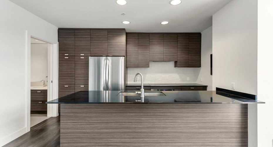 Kitchen features stainless steel appliances, quartz counters & ample cabinet space.