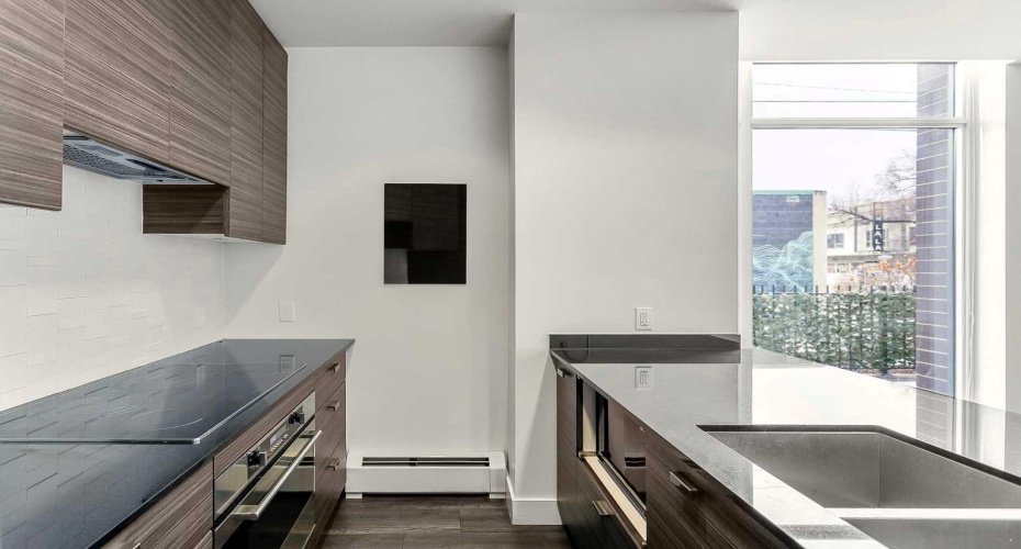 Kitchen features stainless steel appliances, quartz counters & ample cabinet space.