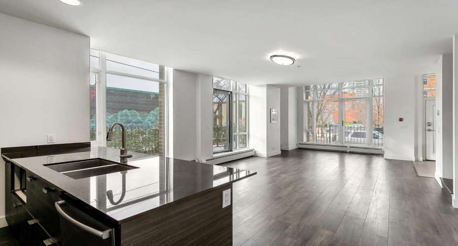 Kitchen features stainless steel appliances, quartz counters & ample cabinet space.