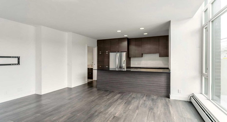Kitchen features stainless steel appliances, quartz counters & ample cabinet space.