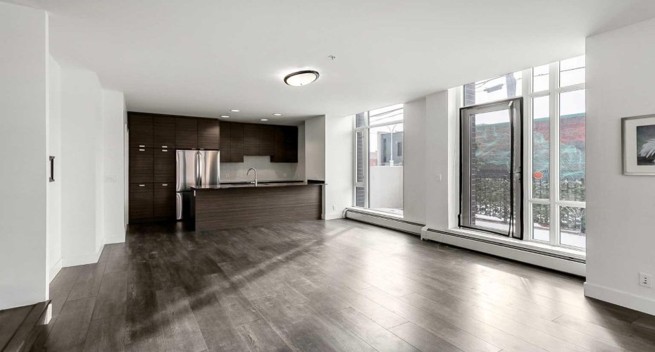 Kitchen features stainless steel appliances, quartz counters & ample cabinet space.