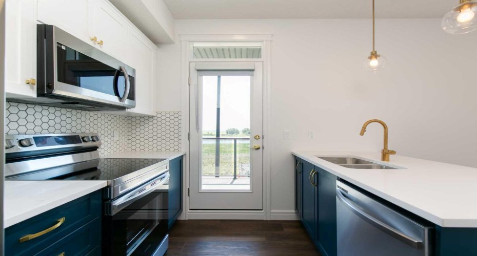 Beautiful golden hardware paired with rich blue cabinets adds a bold and elegant touch to the kitchen