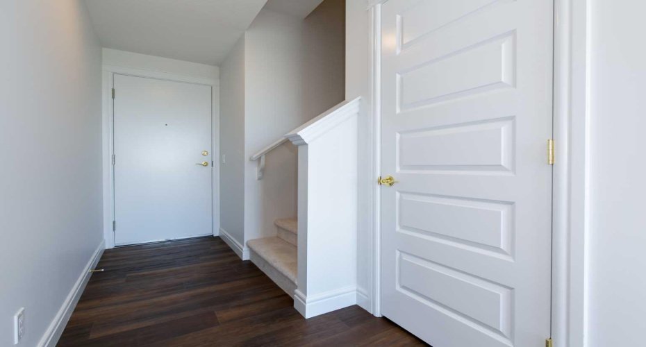 The front entrance boasts a spacious feel with soaring 9 ft ceilings and stylish laminate flooring, combining elegance with practicality