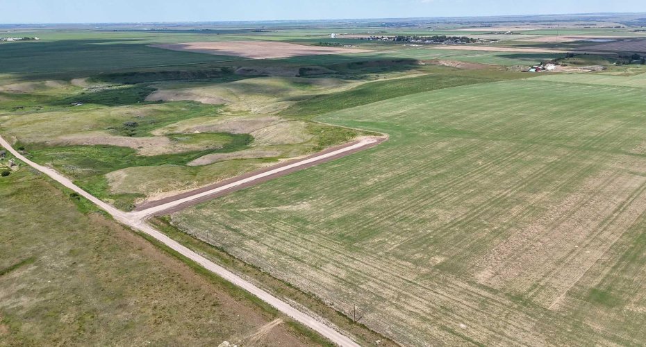 Drone view of property surrounded by prairie lands.