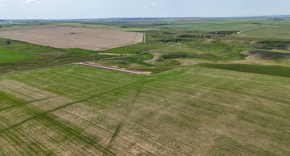 Drone view of acreage surrounded by prairie.
