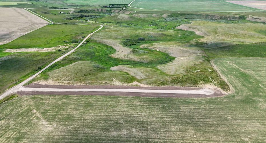 Drone view of acreage with coulee views, creek views and surrounded by prairie.