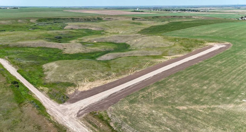 Drone view of acreage with coulee vista views and surrounded by prairie.