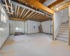 unfinished basement with high ceilings and windows