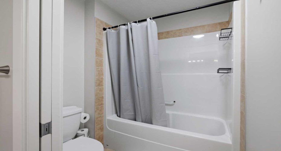 Shower & toilet separated by a pocket door.