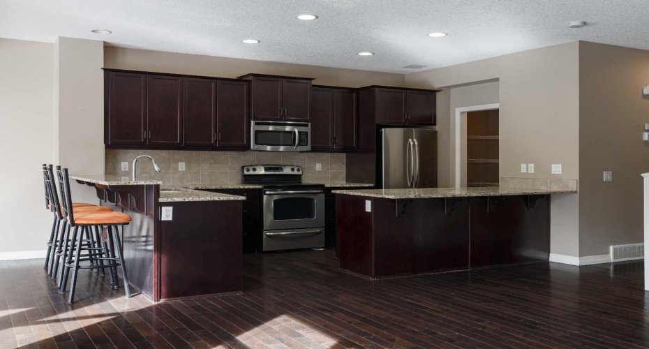 Your gourmet kitchen has lots of granite counter space, cabinets + a wall-in pantry