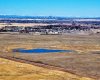 Drone view west. Chestermere High School in midground. Calgary and mountains beyond.