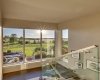 The stairwell to the upper level boasts views over the expansive grounds and brings in endless natural light.
