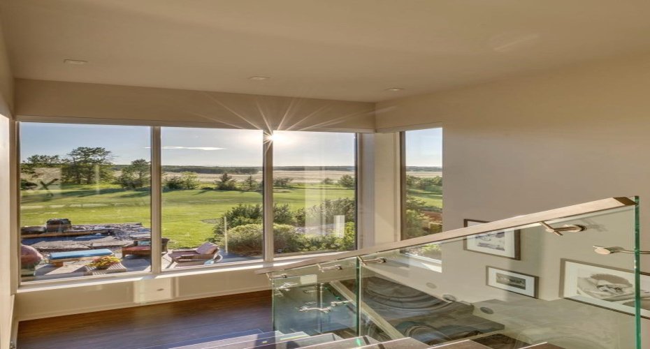 The stairwell to the upper level boasts views over the expansive grounds and brings in endless natural light.