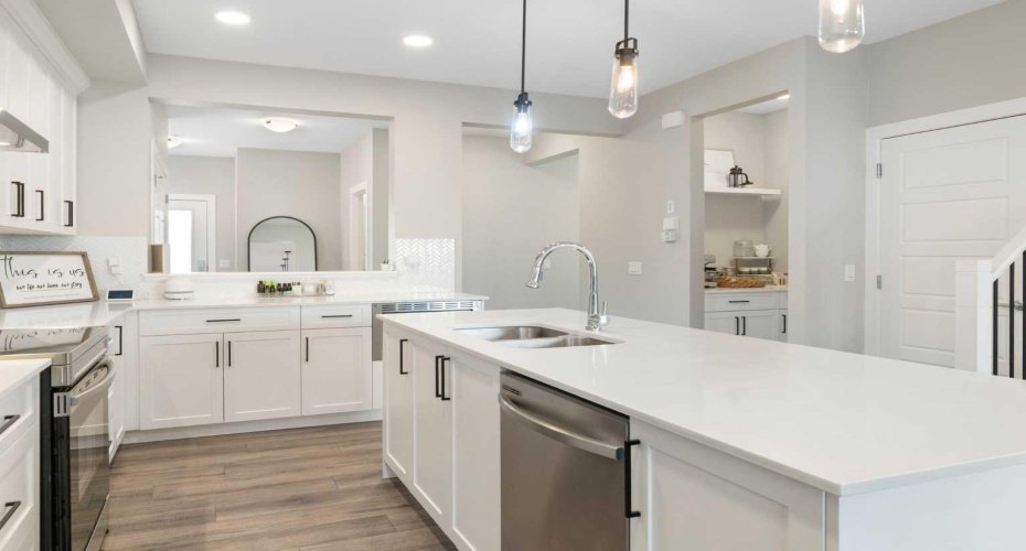 Kitchen with centre island; view to entrance with coffee station and pantry to the right.