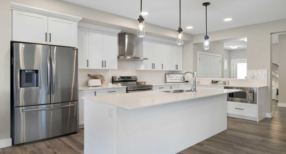 Ample counter space in this bright, beautiful upscale kitchen with stainless-steel appliances and range hood.