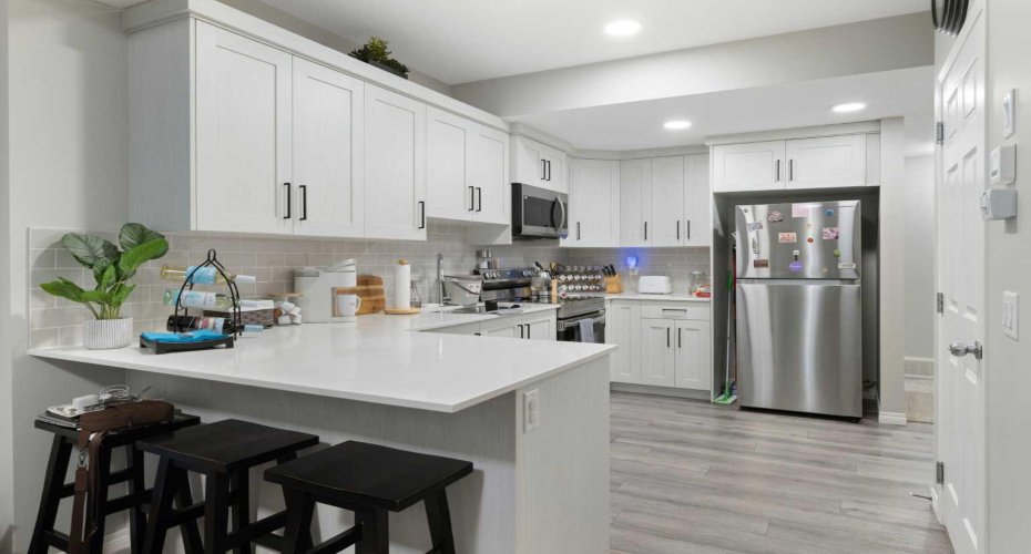 Full kitchen with breakfast bar and stainless-steel appliances in the basement secondary suite