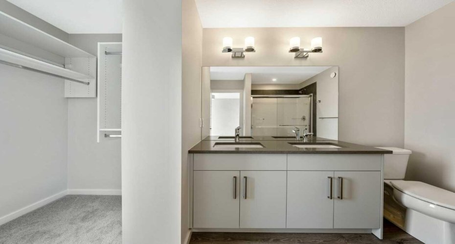 Walk-in closet beside primary ensuite