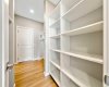 Walkthrough pantry & mud room with melamine shelves and MDF bench w/ coat hooks.