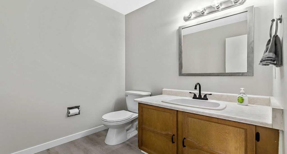 Convenient main floor powder room featuring updated matte black fixtures and refreshed finishes.