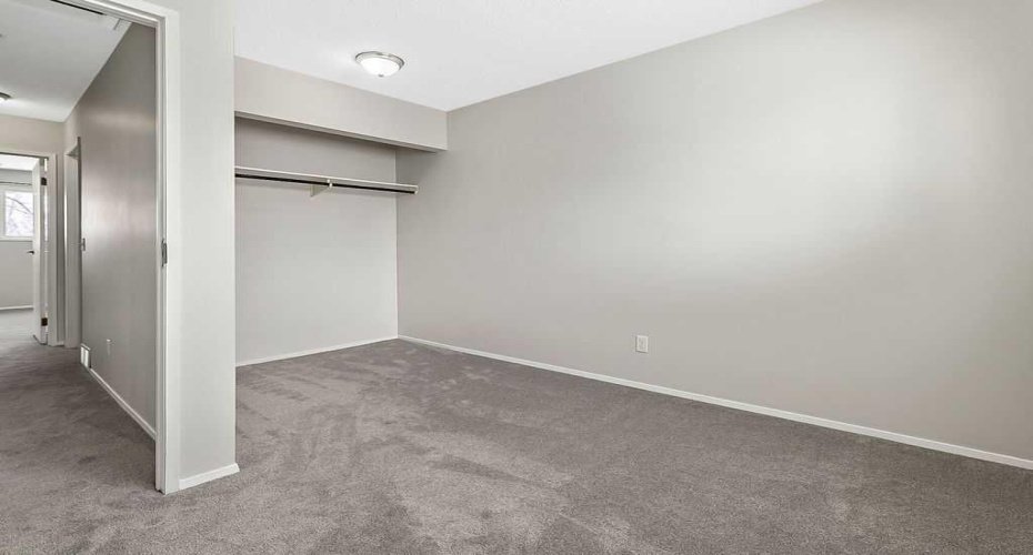 Bright upper-level bedroom with fresh carpet and a generous closet, offering flexible space for kids, guests, or a home office.