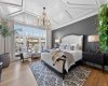 Bright and serene primary suite with elaborate ceiling detail and motorized blackout drapes and blinds.