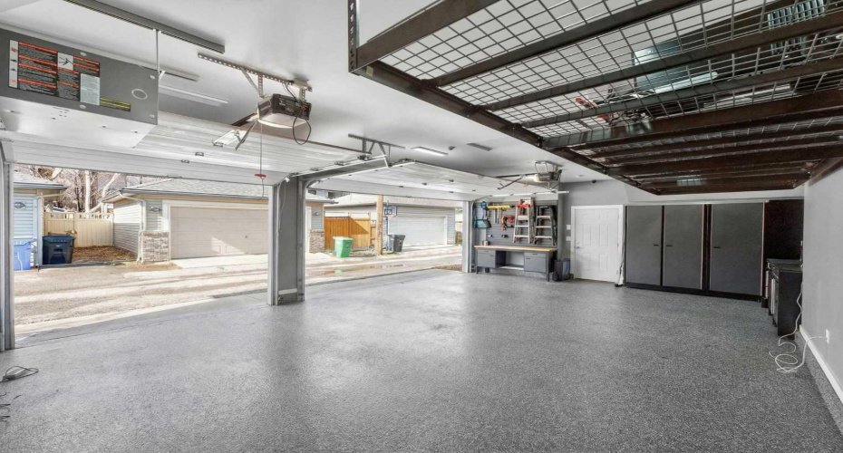 Triple heated garage with epoxy floor, metal cabinetry, and gas heater — room for vehicles and more.