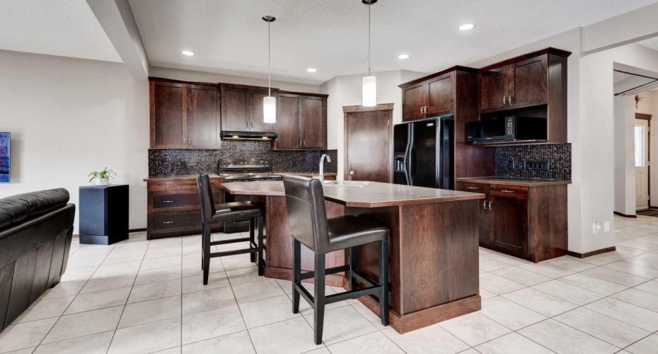 kitchen Island , pendant lights, tile backsplash, 9 ft ceilings, undermount l cabinet lights, over height cabinets