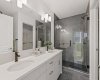 Primary ensuite with dual sinks and walk-in tiled shower.